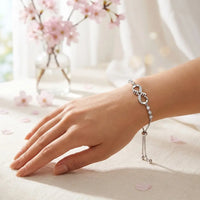 Woman wearing silver infinity love bracelet with Mom 
engraved heart crystal design on wrist