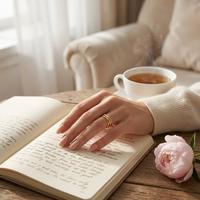 Gold interlocked fidget ring worn during calm self-care 
journaling moment with herbal tea