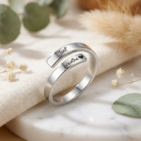 Macro detail of Just breathe engraving on silver 
adjustable wrap ring with heart symbol — premium 
stainless steel mindfulness jewelry