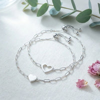 Matching Hearts Bracelet Set in silver with 
solid heart and open heart on cream linen 
— sterling silver 2-piece bond bracelet set