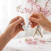 Mother and daughter hands holding matching heart keychain set together emotional bond