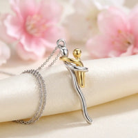 Mommy and me hug necklace pendant close-up two-tone silver mother gold child embrace detail