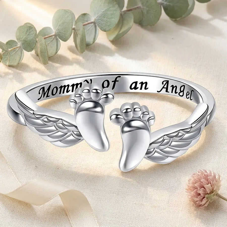 Two baby feet wrapped in angel wings.