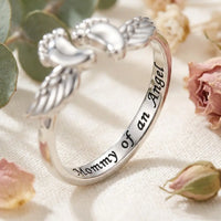 Macro detail of Mommy of an Angel cursive 
script engraving inside silver ring band — 
heartfelt memorial jewelry for baby loss