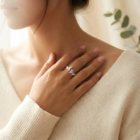 Woman wearing Mommy of an Angel memorial ring 
with hand resting near heart — sterling silver 
keepsake honoring angel babies