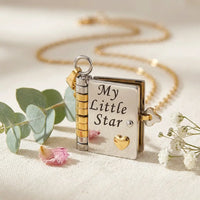 Macro detail of My Little Star cursive 
engraving on silver book locket pendant with 
gold heart and key clasp — premium daughter 
keepsake jewelry