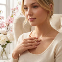 Young woman wearing gold Linked Forever necklace interlocking heart pendant on collarbone